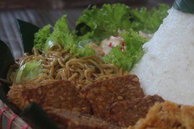 Nasi Tumpeng. Koni şeklinde sarı pirinç. Şenlikli bir Endonezya pirinç yemeği ve mezeler dini etkinliklerde servis edilir..