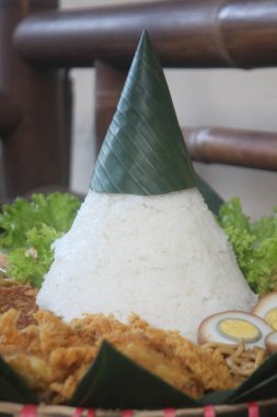 Nasi Tumpeng. Koni şeklinde sarı pirinç. Şenlikli bir Endonezya pirinç yemeği ve mezeler dini etkinliklerde servis edilir..