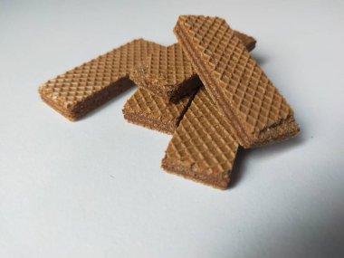 Üstüste yığılmış dikdörtgen çikolatalı gofretler beyaz arka planda..