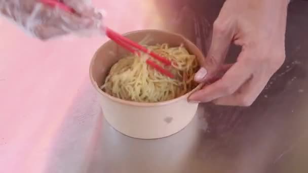 젓가락을 사용하여 그릇에 국수를 닭고기 추가하는 — 비디오