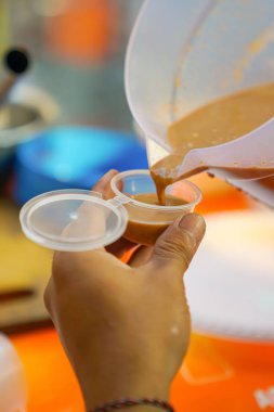 Fıstık sosu ızgara otakların daha yakın görünmesi için küçük bir yere dökülüyor.