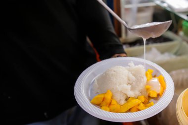 Close up view of a chef preparing sticky rice with milk that is so tempting in the mouth clipart