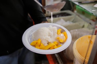 Close up view of a chef preparing sticky rice with milk clipart