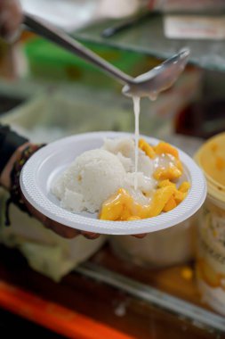 Jackfruit sticky rice is being given white milk on top by the chef clipart