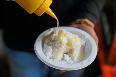 Sticky rice being given white milk by the chef, close up clipart