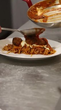 Kırmızı soslu beyaz tabakta köfte ve spagetti. İtalyan restoranı videoları, yemek videoları, stok videoları için mükemmel..