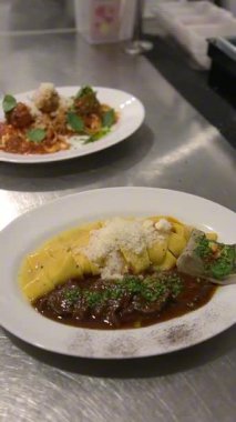 Masada et soslu ve peynirli iki tabak makarna. Yemek videoları, restoran videoları ya da İtalyan yemek videoları için mükemmel..