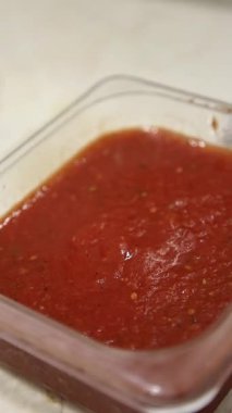 Pizza hamuruna domates sosunu ustaca yaymak. Yemek videoları, restoran videoları, yemek videoları, pizzayla ilgili pazarlama malzemeleri için mükemmel..