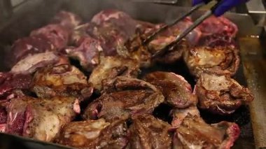 Arkasında maşayla ızgara et. Yemek videoları, restoran tanıtım videoları, barbekü reklamları, aşçılık videoları ve yaz ızgara konseptleri için uygundur..