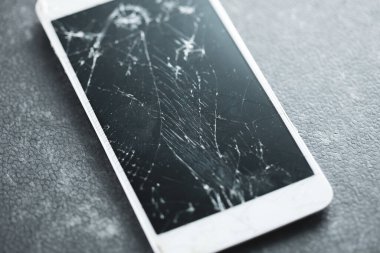 Masadaki kırık akıllı telefon.