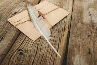 Ahşap masa zemininde tüy ve harf