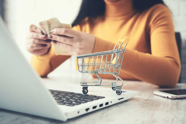 stock image woman hand holding money with computer