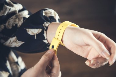 Kadın el sarısı akıllı saat koyu arkaplanda