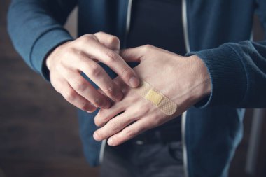 Adam el bandajı koyu arkaplanda.