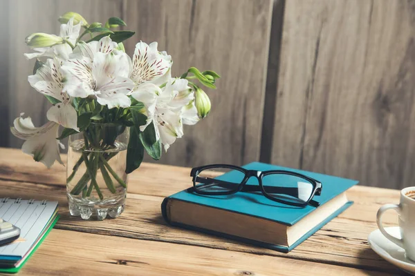 flowers on book  with coffee on desk