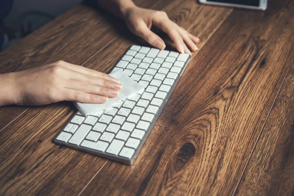 woman clean keyboard in napkin on the desk