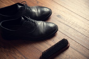 Açıkça görülüyor ve tahta masa arkasında ayakkabılar var.