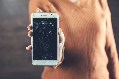 Kadın eli kırılmış, arka planda akıllı telefon var.