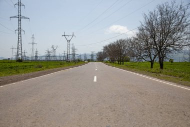 Elektrik kulesi ve boş asfalt yol arkaplanı