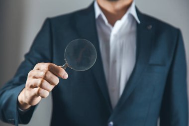 Adam el büyüteci gri duvar arka planında