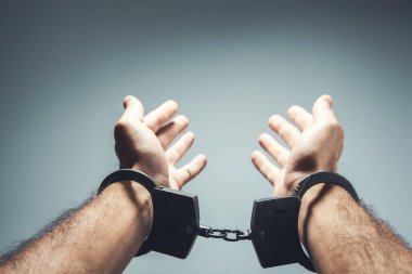 Gri bir sırt grubuna kelepçelenmiş ellerle yakın çekim