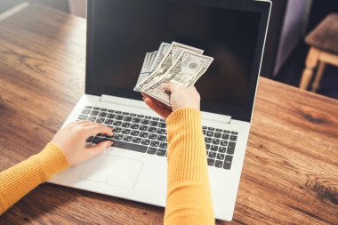 Kadınlar masadaki parayı ve bilgisayarı verir.