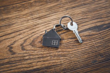 Ahşap masa arkasındaki ev anahtarı.