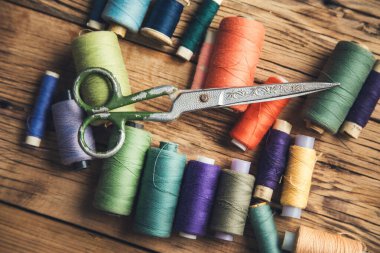 Ahşap masada renkli iplikler ve makas