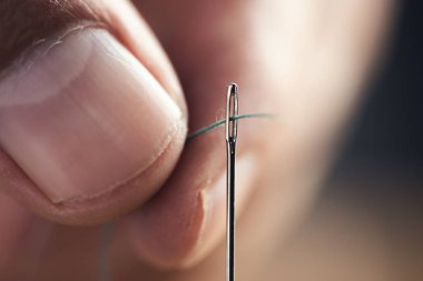 Adam iğneyi siyah arkaplanda gezdiriyor.