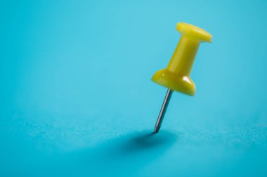 Mavi arka planda plastik bir raptiyenin yakın plan çekimi.