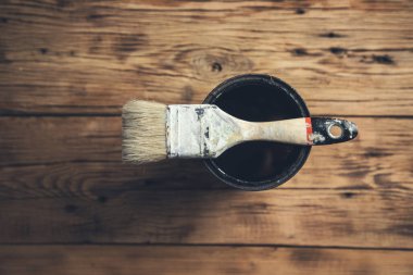 Tahta masadaki boya kabını fırçala.