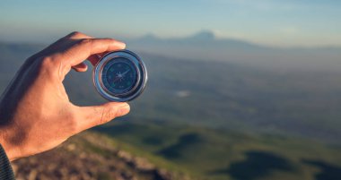Adam el pusulası dağ arka planında
