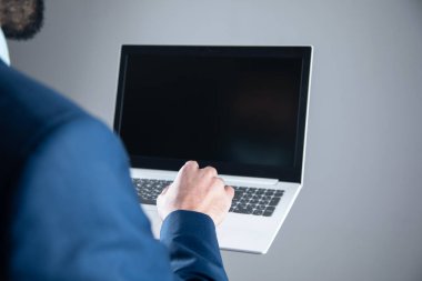 Koyu arka plan üstünde laptop ile yakışıklı genç