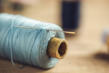 Masadaki mavi iplikte iğne var.