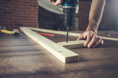 İşçi el matkaplarıyla odunları yakın mesafeden delin