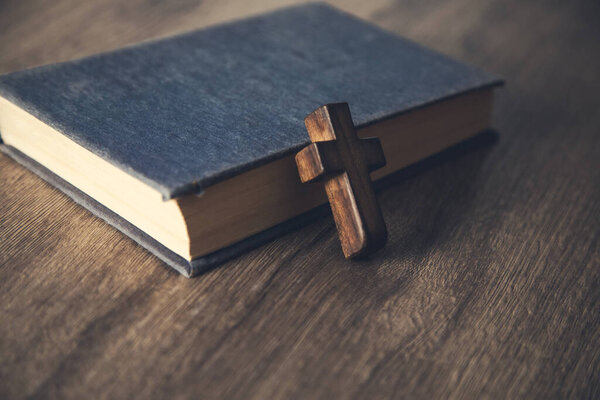 wooden cross on the Bible on the table