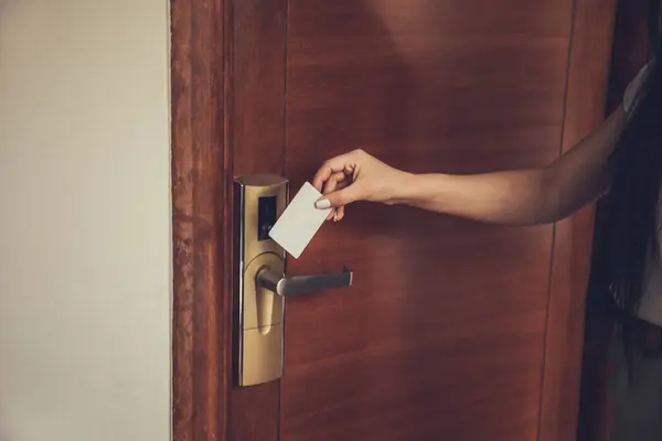 woman opening hotel room electronic lock with key card