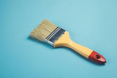 Mavi masa arka planında boya fırçası