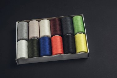 Siyah arkaplanda renkli dikiş iplikleri