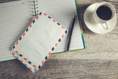 Masada kahve olan not defteri ve mektup.