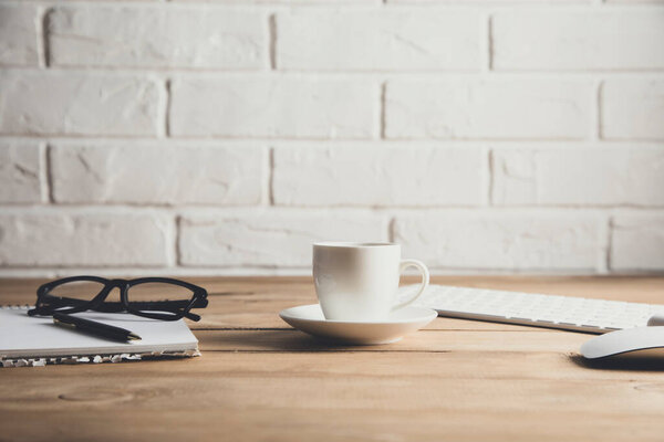 computer with notepad and coffee on table