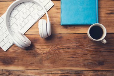 Klavyeli kulaklık ve masada kahve.