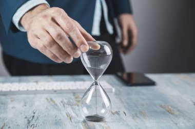 Genç işadamı Han 'ında kum saati tutuyor.