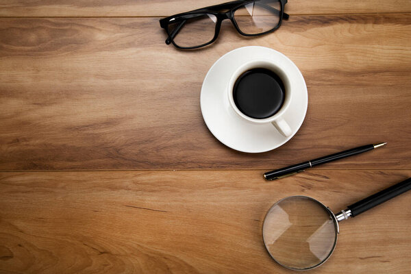 Увеличитель со стеклами и кофе на столе