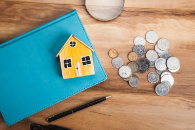 Masada bozuk paralarla kitap üzerinde ev modeli