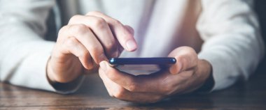 young man hand phone on desk