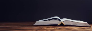 Tahta masanın üzerinde antika bir kitap aç.