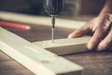 İşçi el matkaplarıyla odunları yakın mesafeden delin