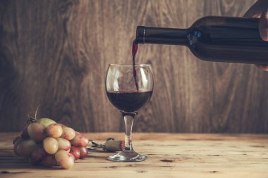 Masadaki bir bardağa üzüm şarabı dolduruyorum.