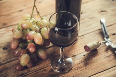 Üzüm şarabı şişesi ve masada açacağı olan cam.